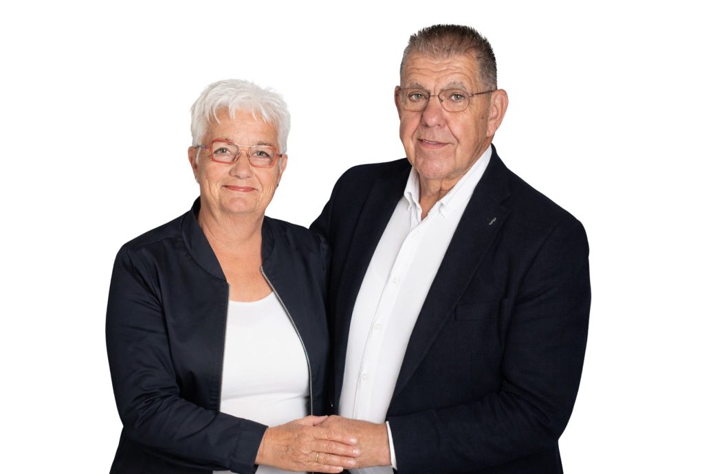 Oud echtpaar poseert samen in nette kleding tegen een witte achtergrond