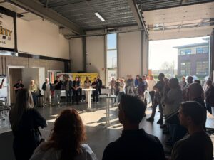 Groep mensen verzameld in een werkplaats tijdens een netwerkbijeenkomst met presentatie