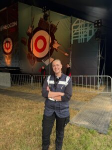 Medewerker van Scenebouw staat voor het podium van de NEDCON Stage tijdens een evenement.